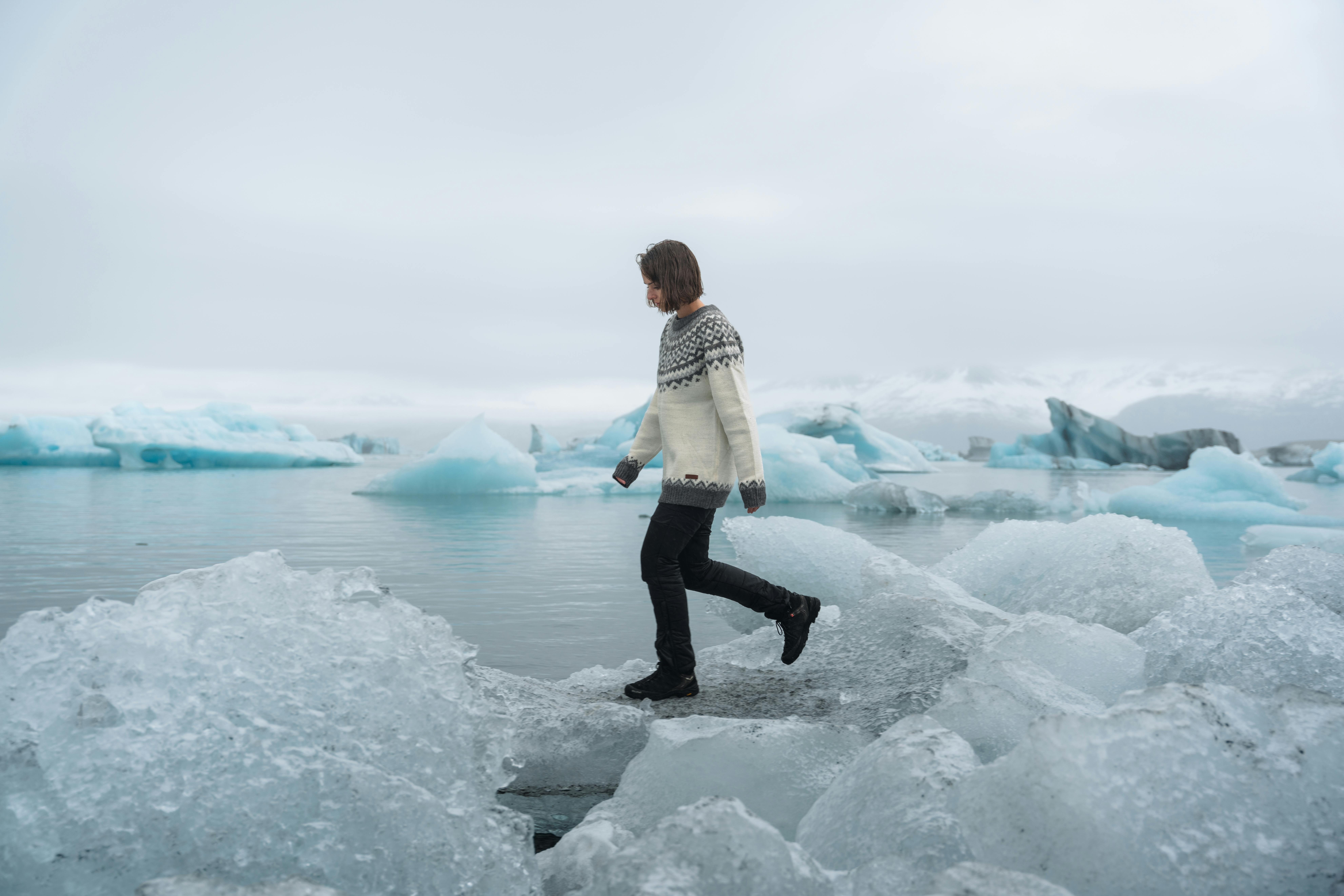 Femme marchant sur des icebergs à la lagune glaciaire
