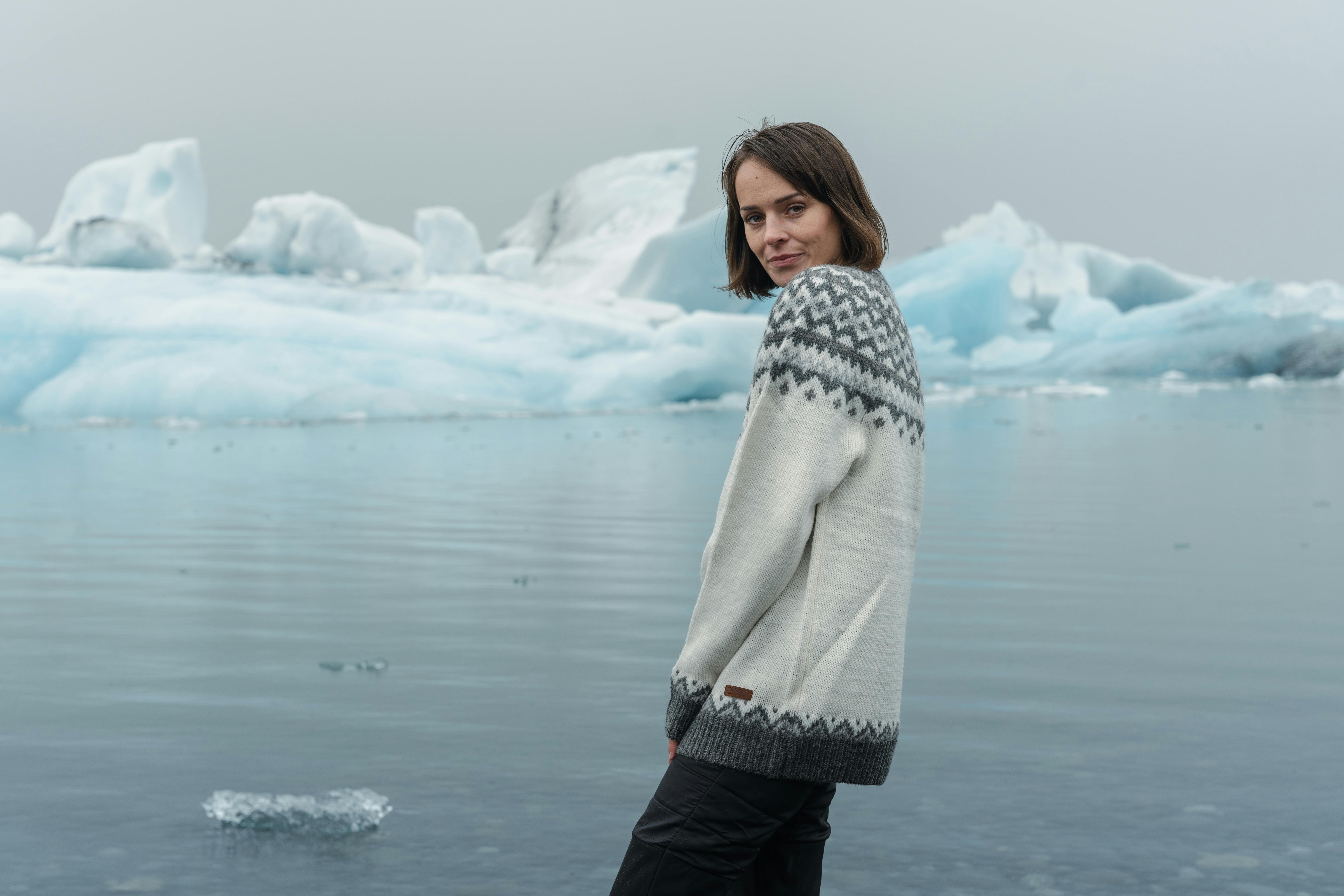 Frau steht an der Gletscherlagune