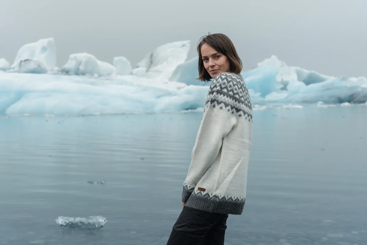 Frau steht an der Gletscherlagune