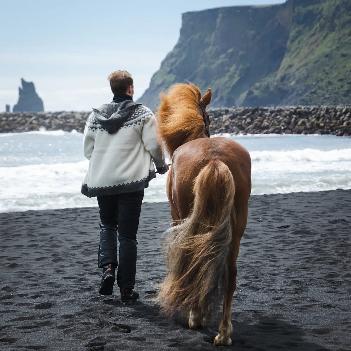 Mann und Pferd am Black Beach, Südisland
