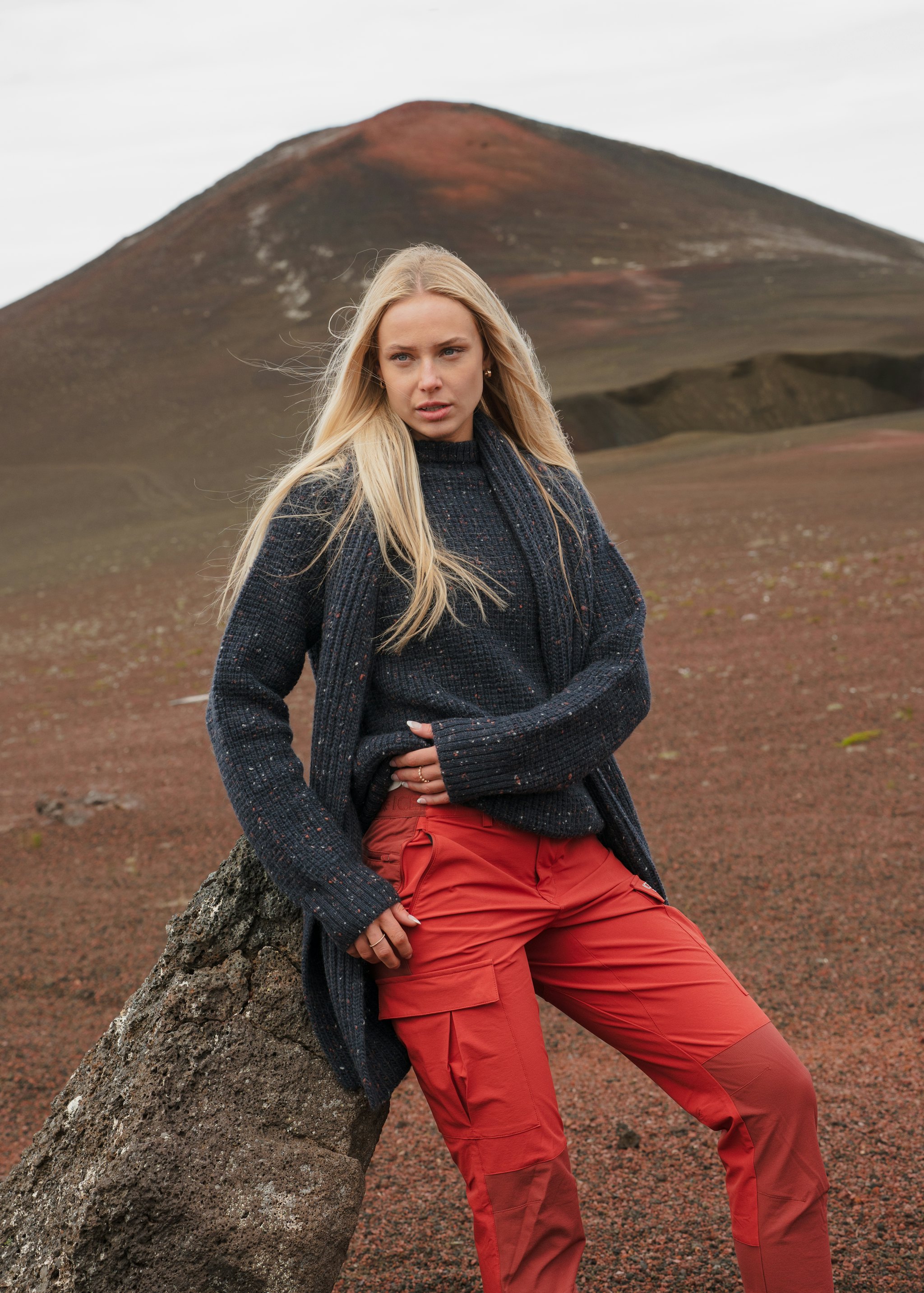 woman sitting on a rock in red pants