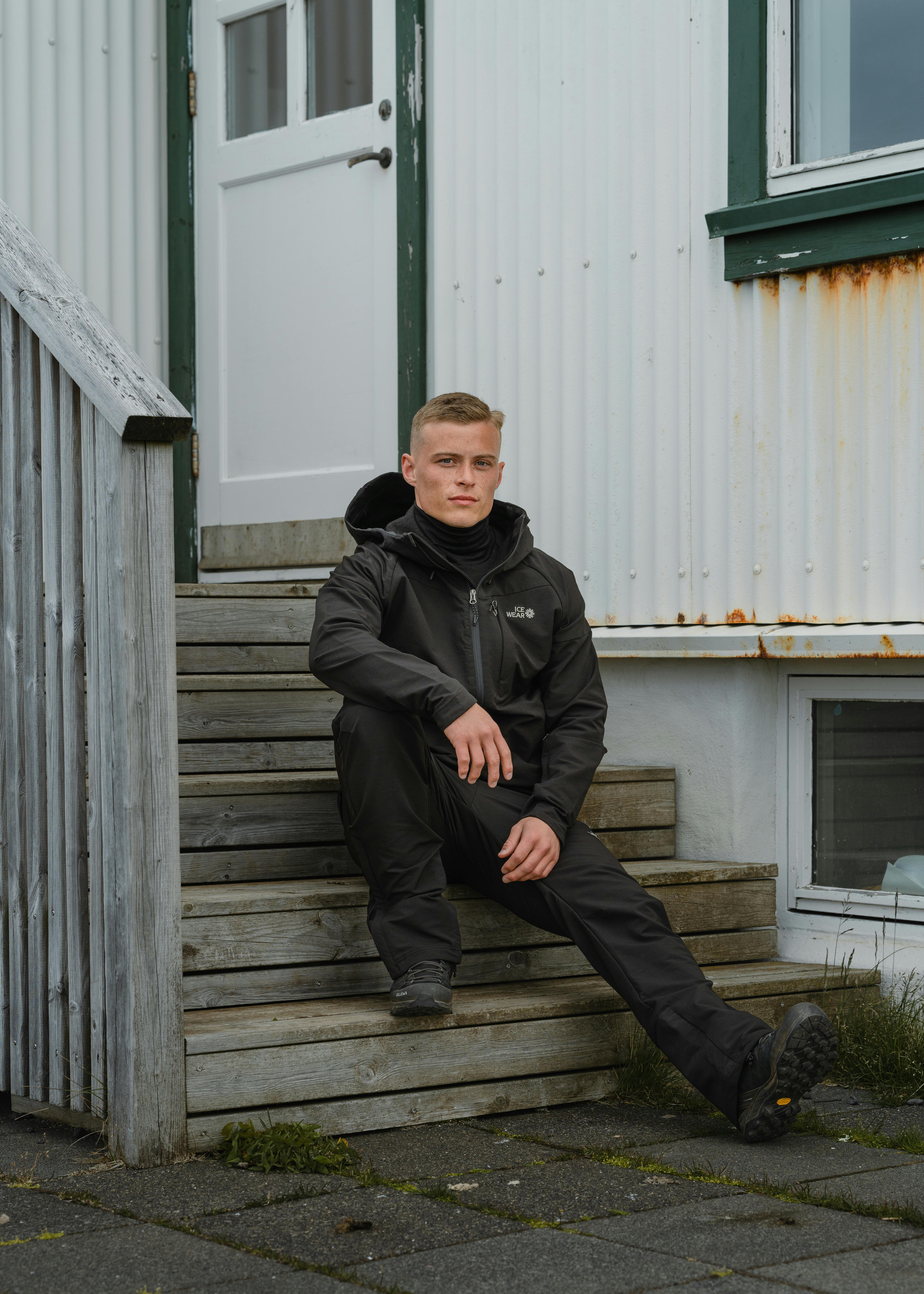 A man sitting on the steps outside an old house