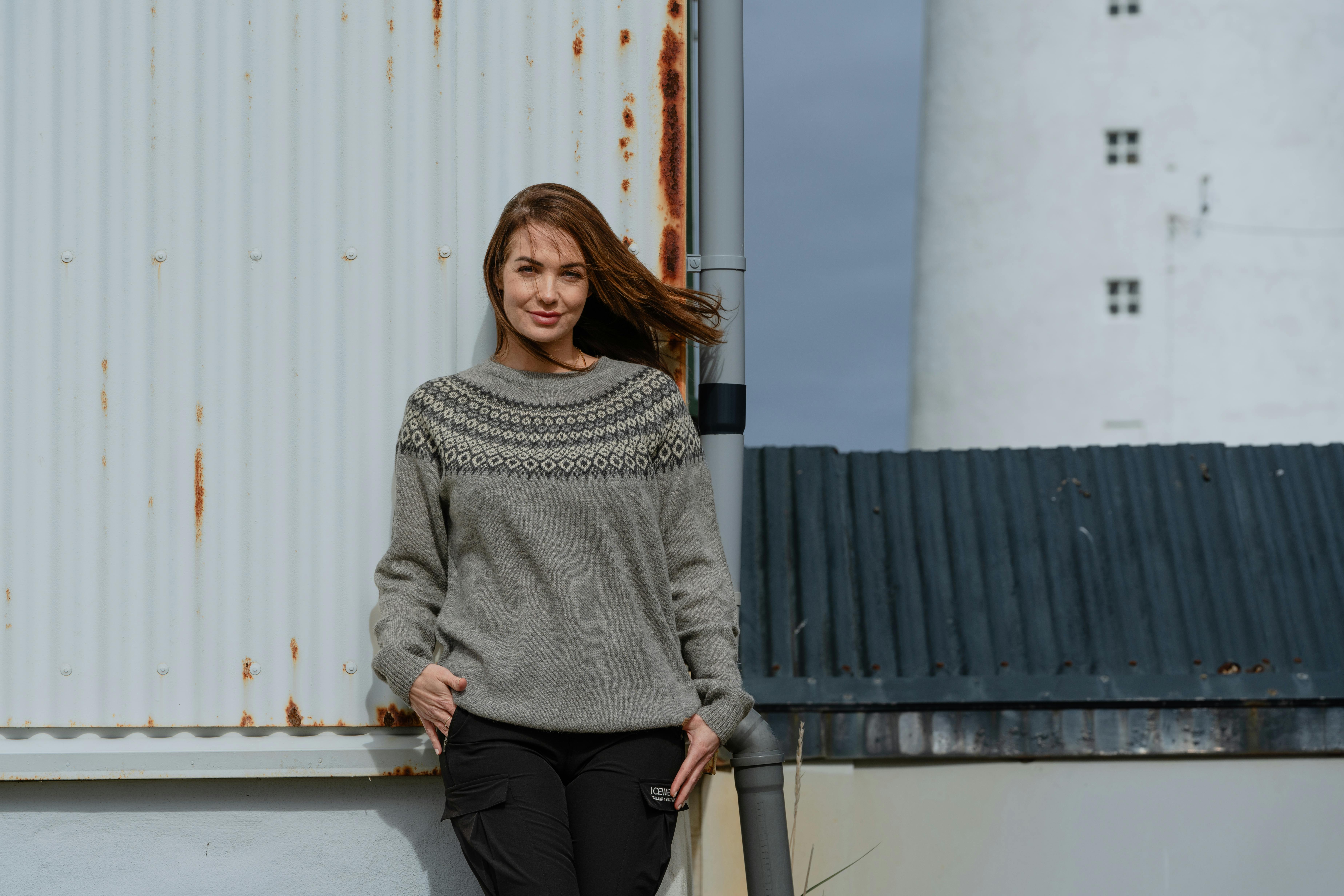 Woman standing up by an old house