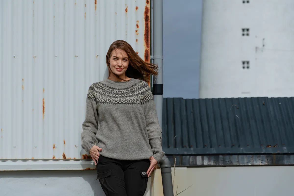 Woman standing up by an old house