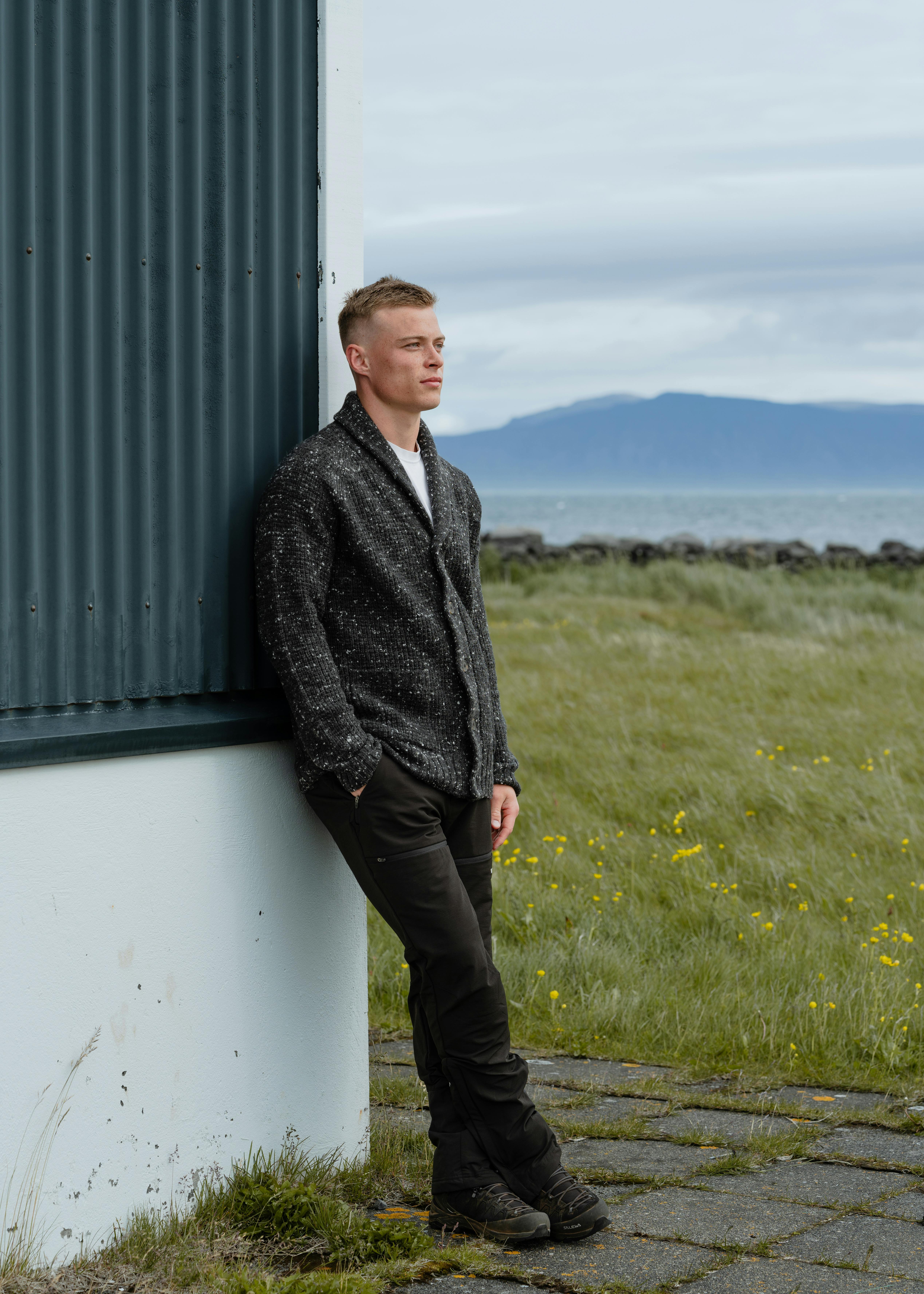 man standing next to a old house