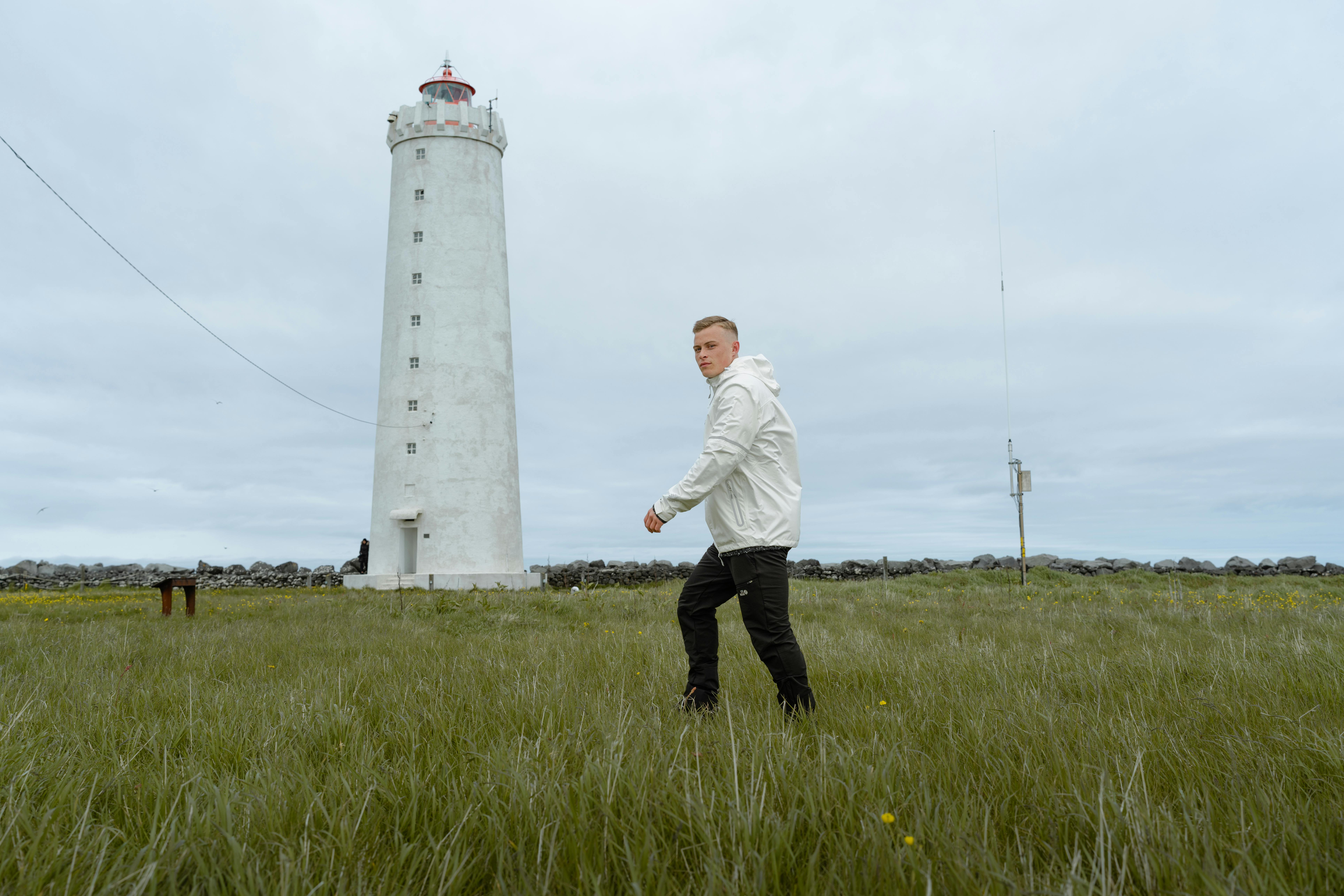 A man walking to an old lighthouse