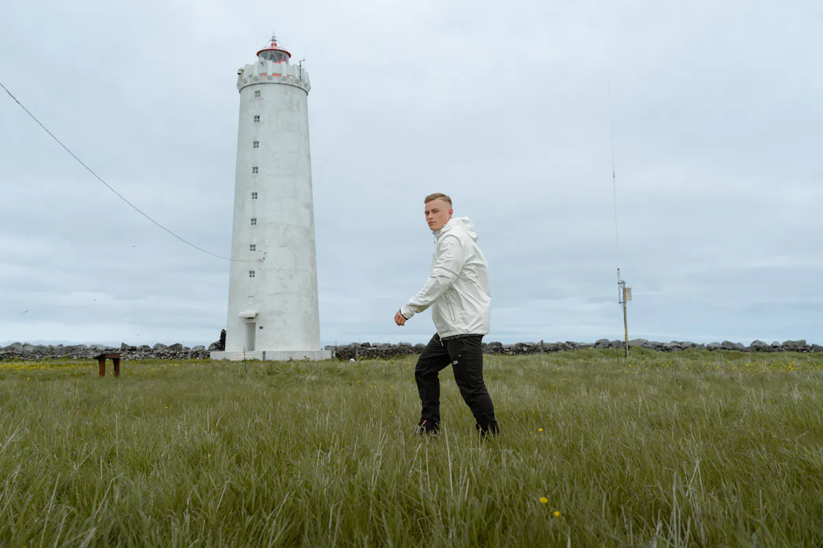 A man walking to an old lighthouse