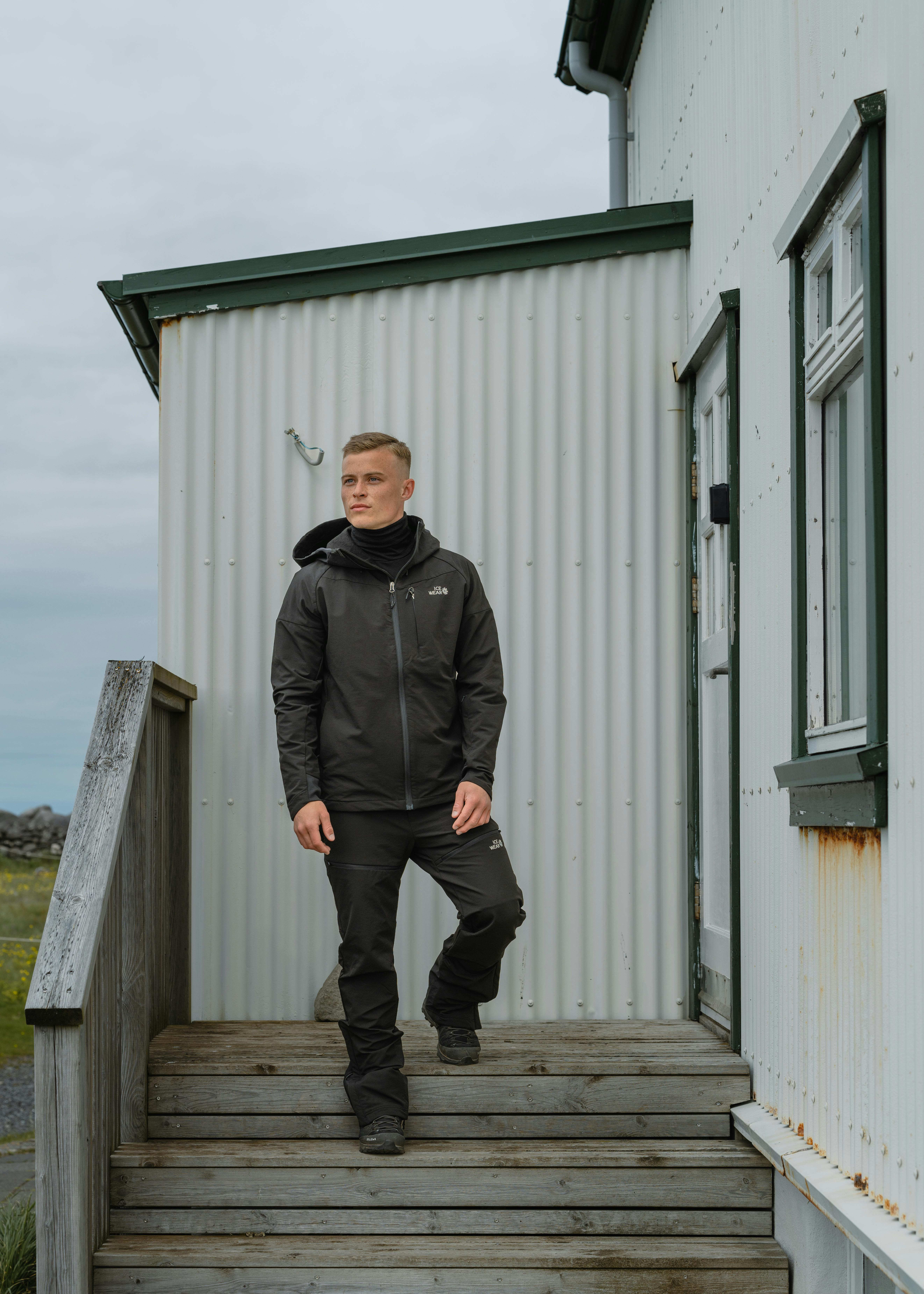 man standing next to a old house