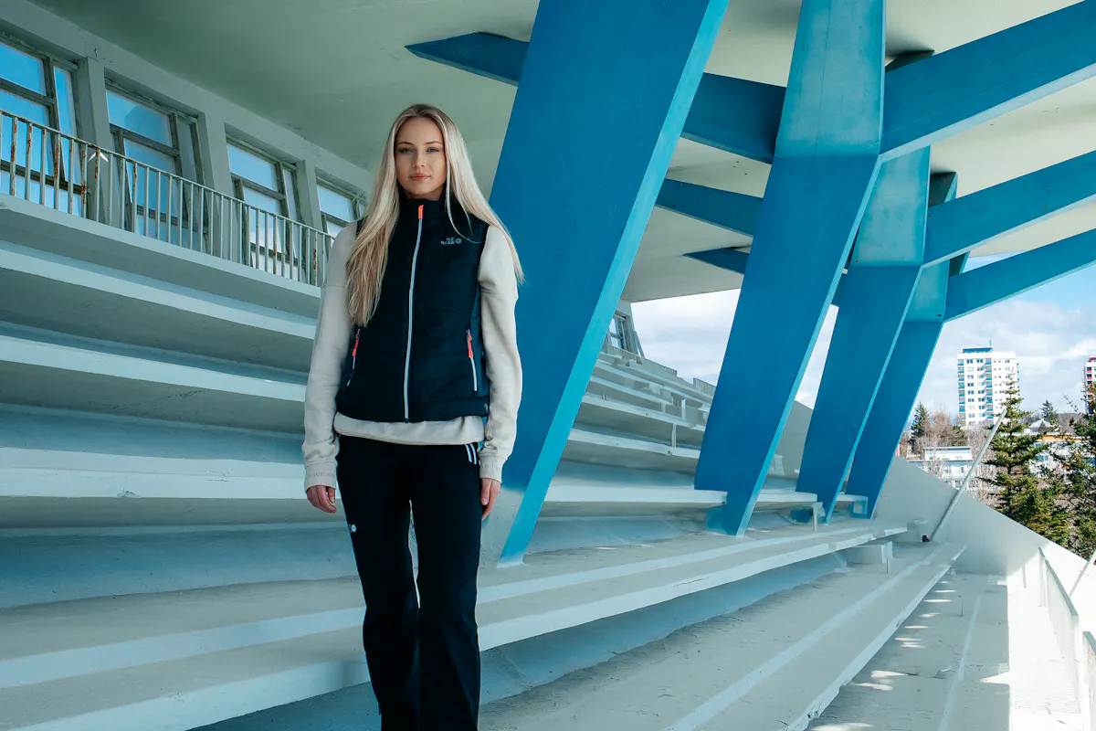 eine Frau in einer Weste an einem Schwimmbad in Reykjavík, Laugardalslaug