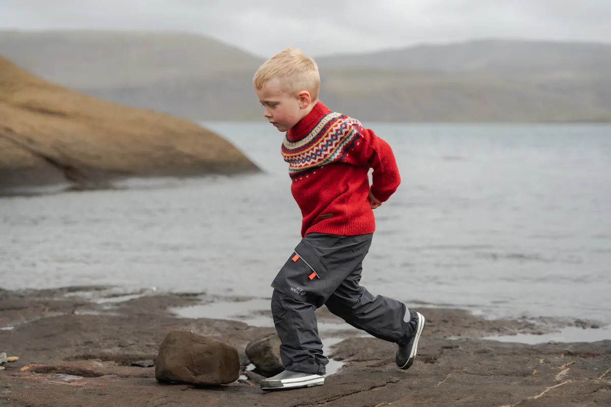 boy running close to the lake