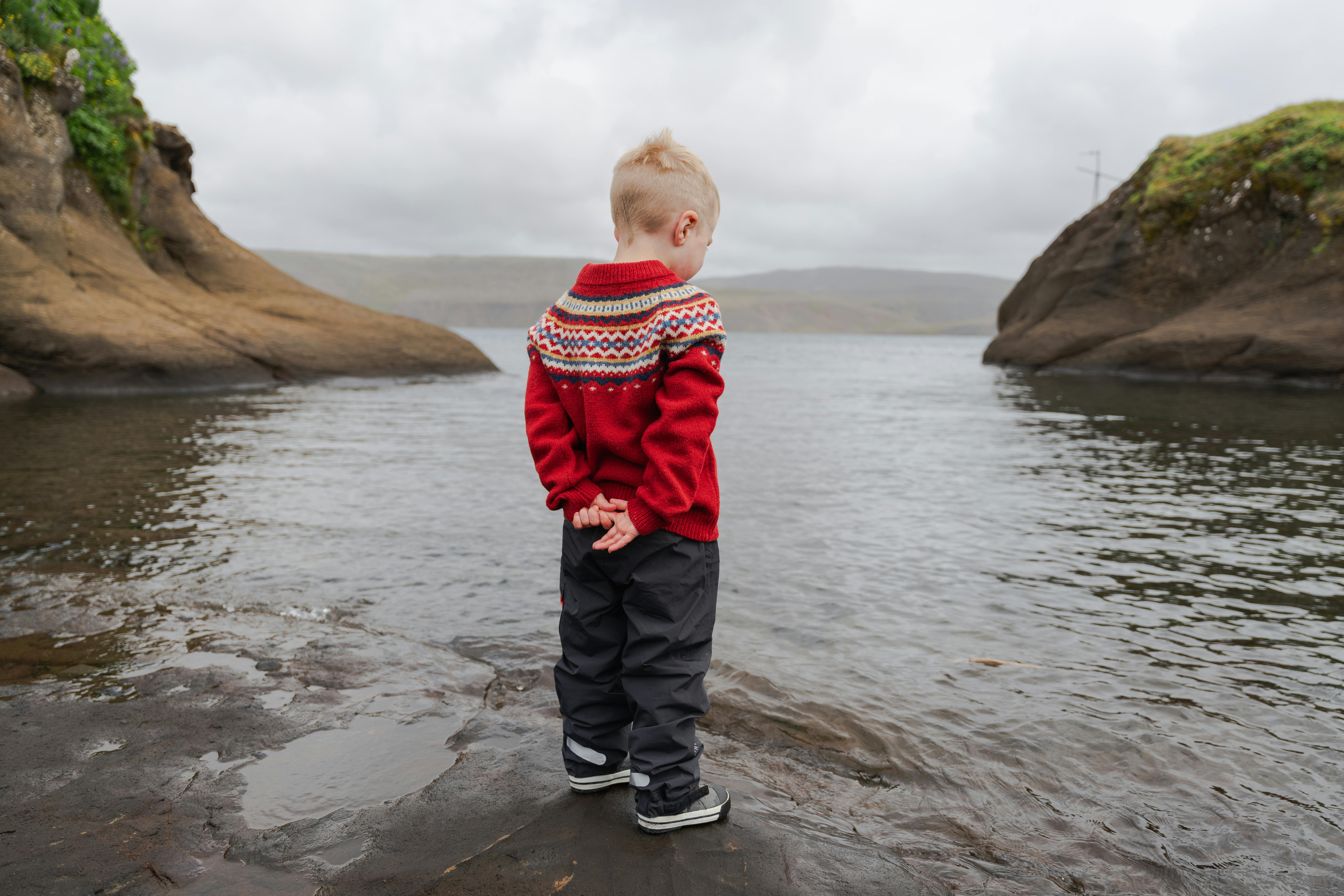 boy standing next to a lake in Iceland