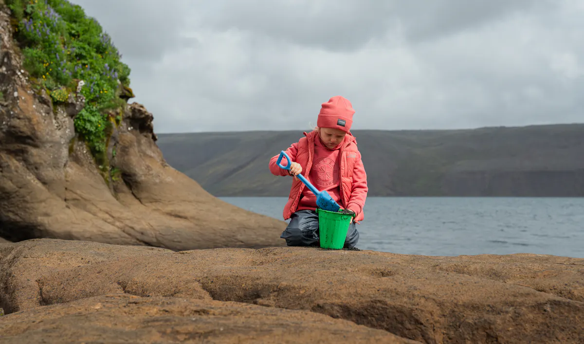 Boy shovelling in a bucket.