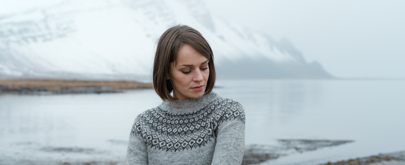 woman with sea and mountain behind her