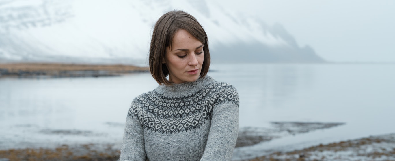 woman with sea and mountain behind her