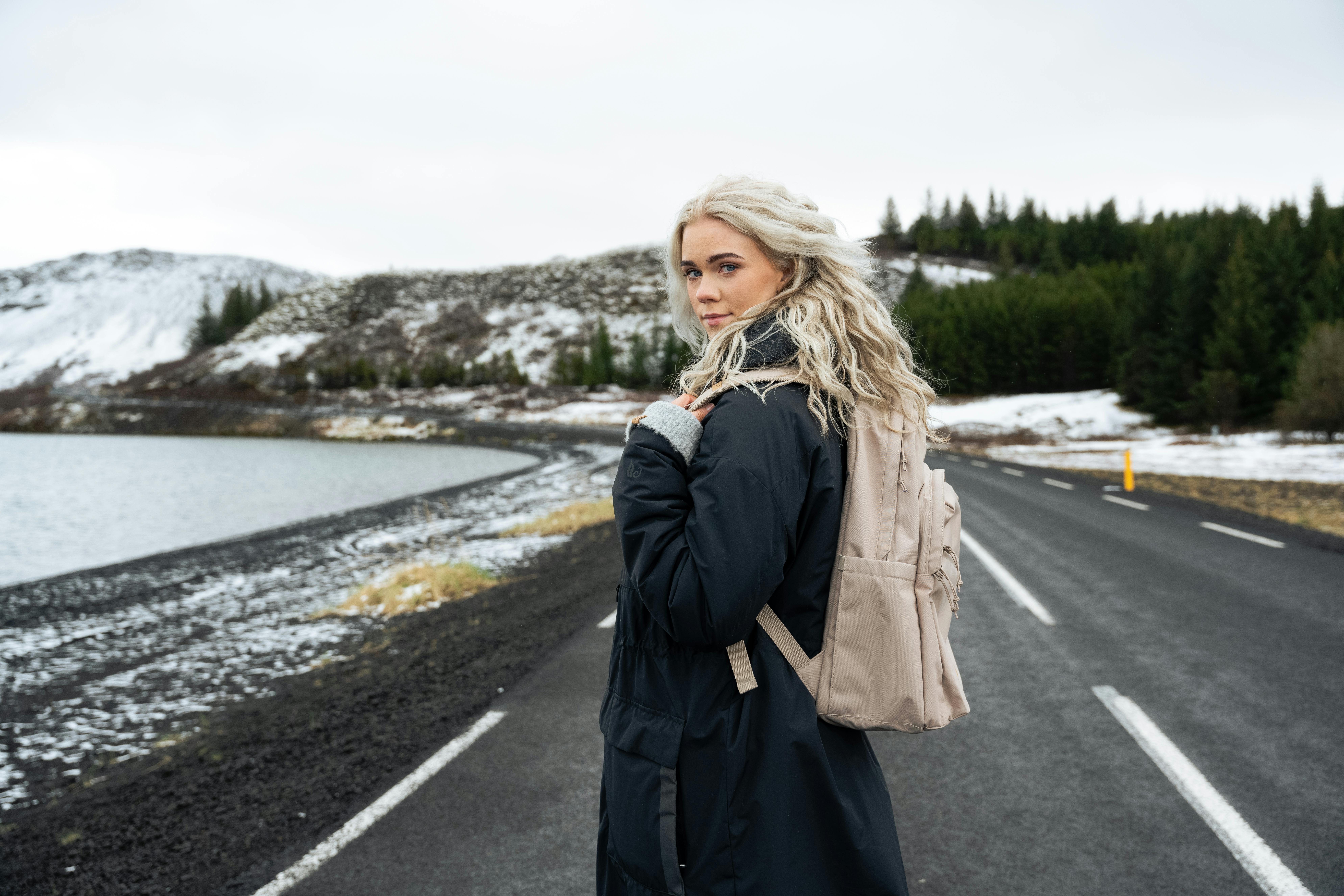une femme marchant sur une route en Islande