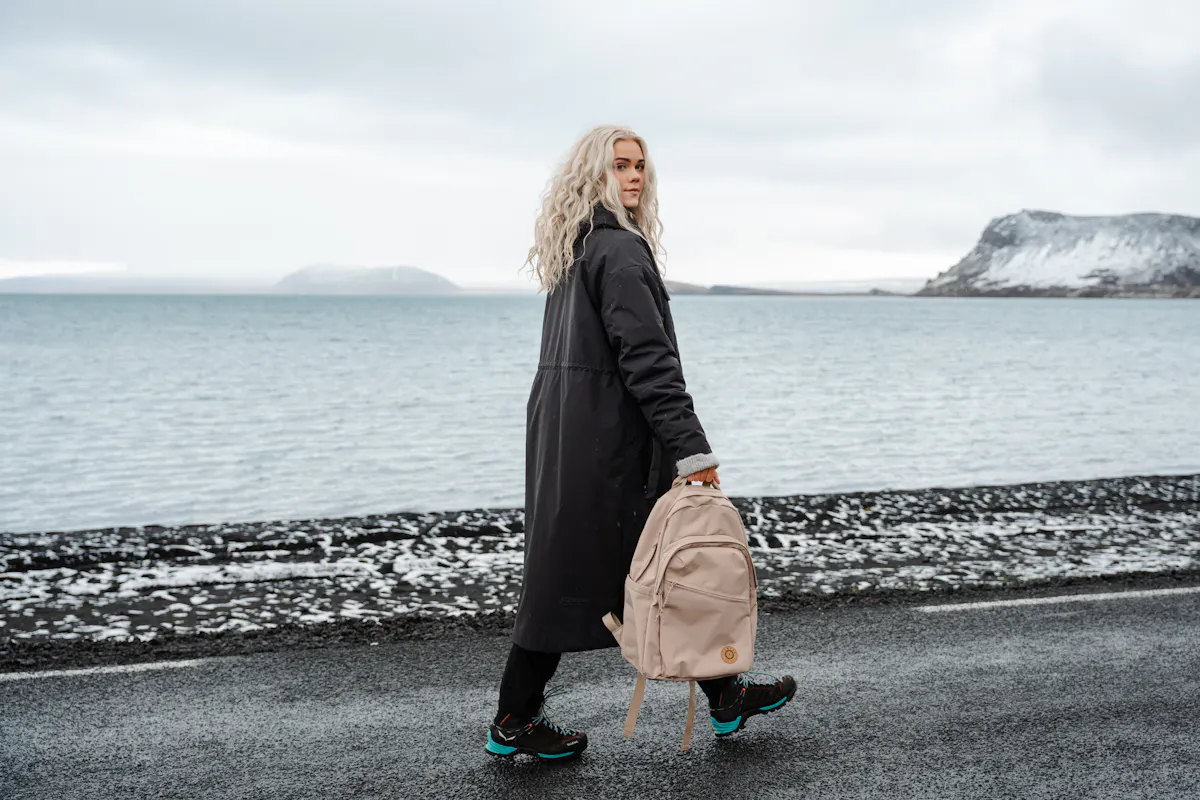 woman with backpack walking on the road