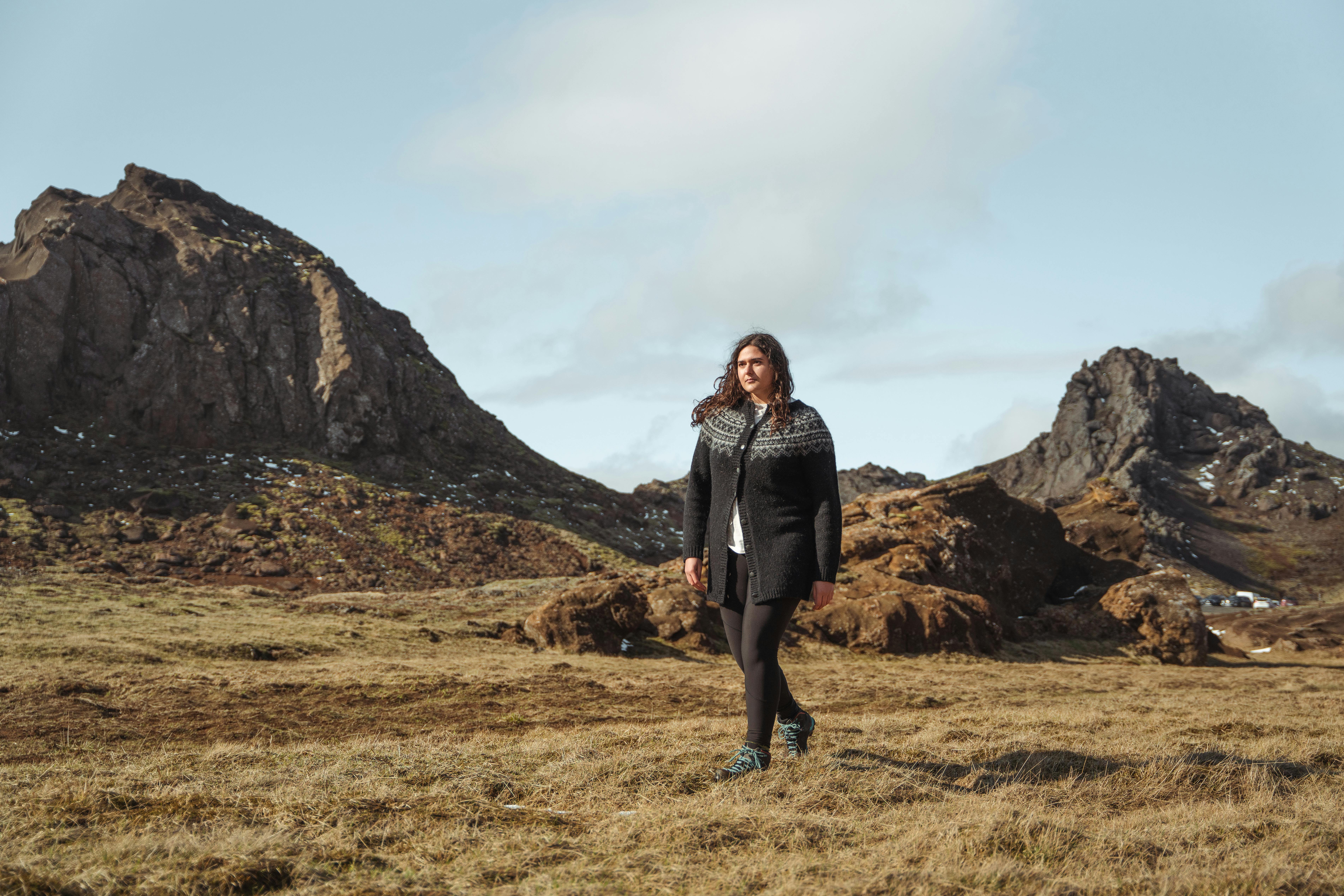 Eine Frau, die in der isländischen Natur spazieren geht