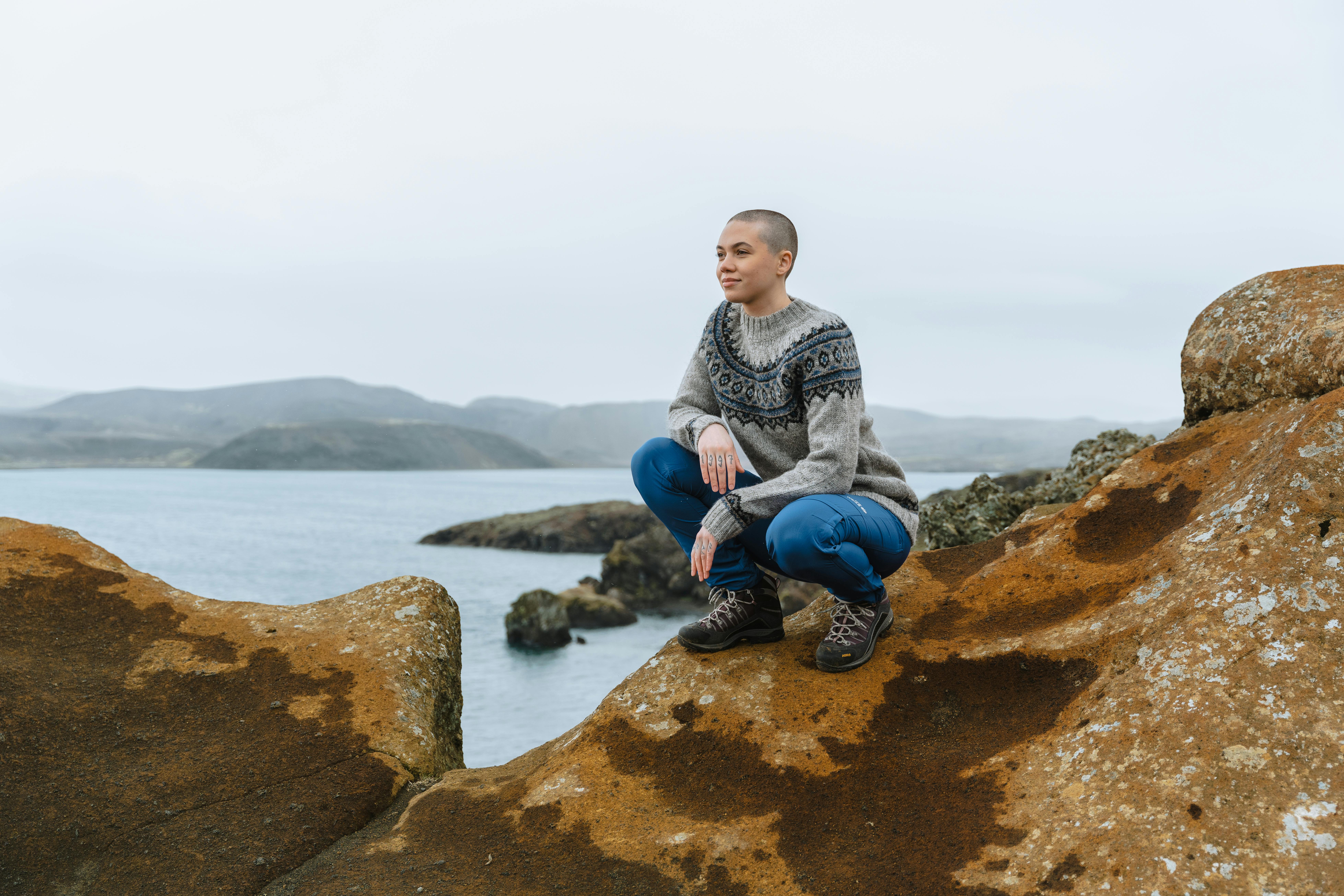 woman on a cliff next to the sea