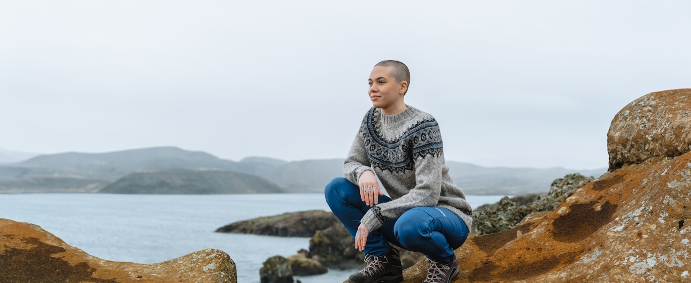 Une femme sur une falaise, la mer derrière elle