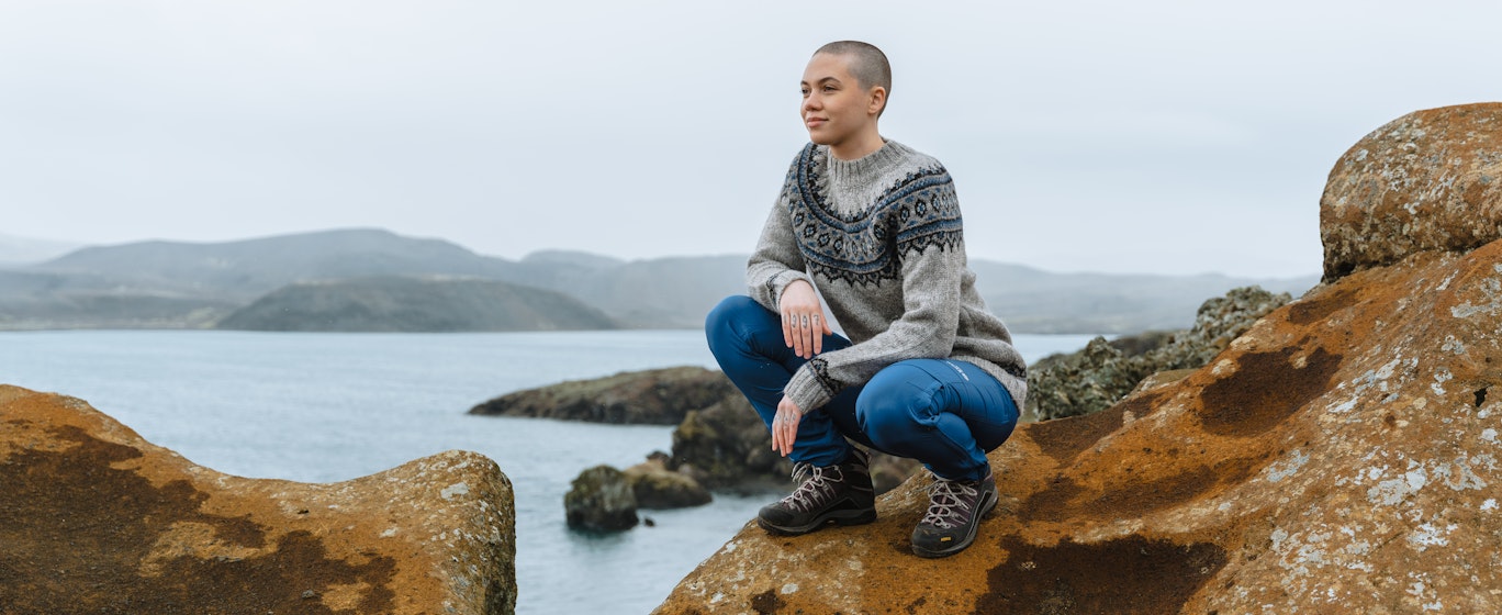 Frau auf einer Klippe an einem See