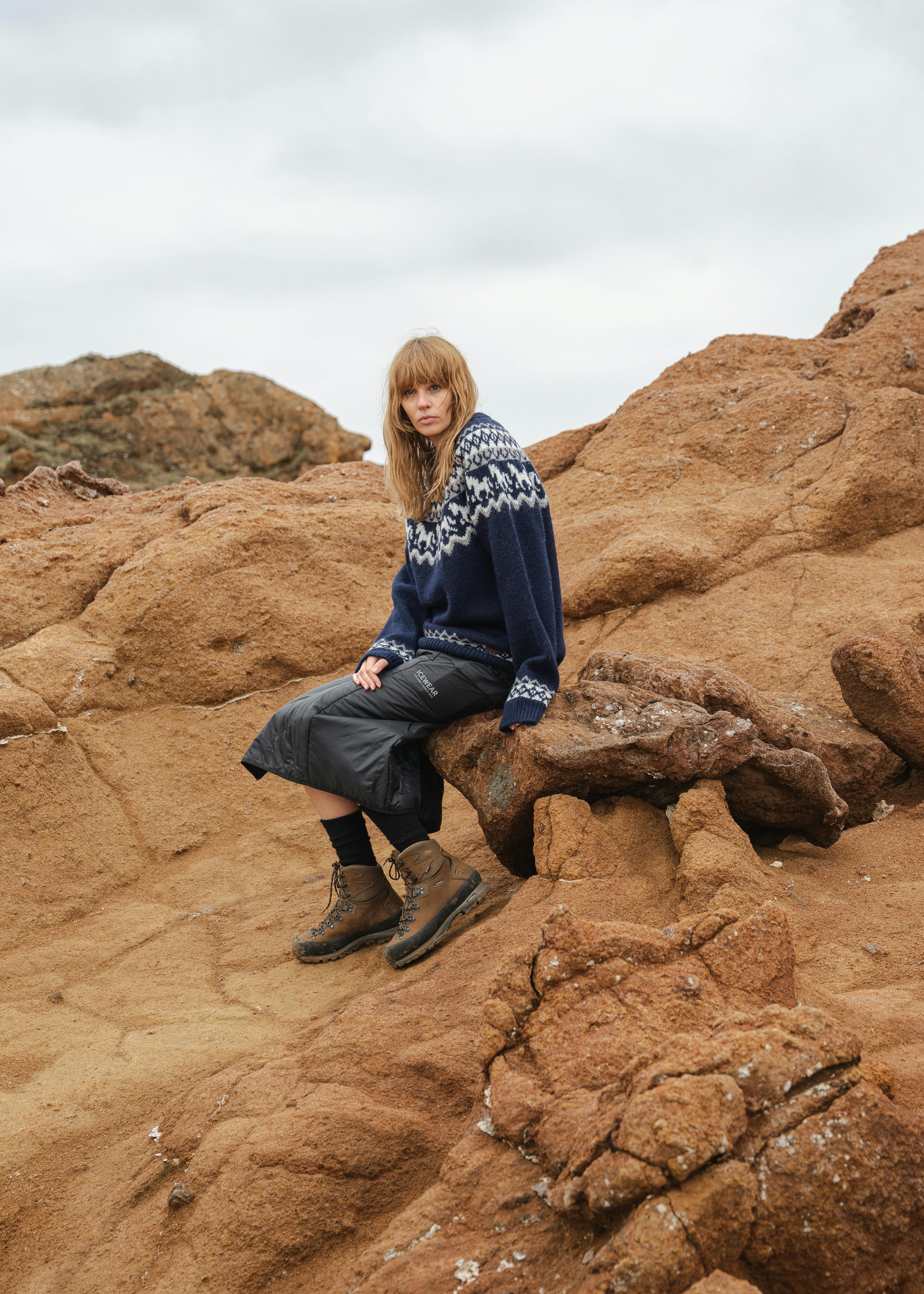 Frau sitzt auf einer Klippe