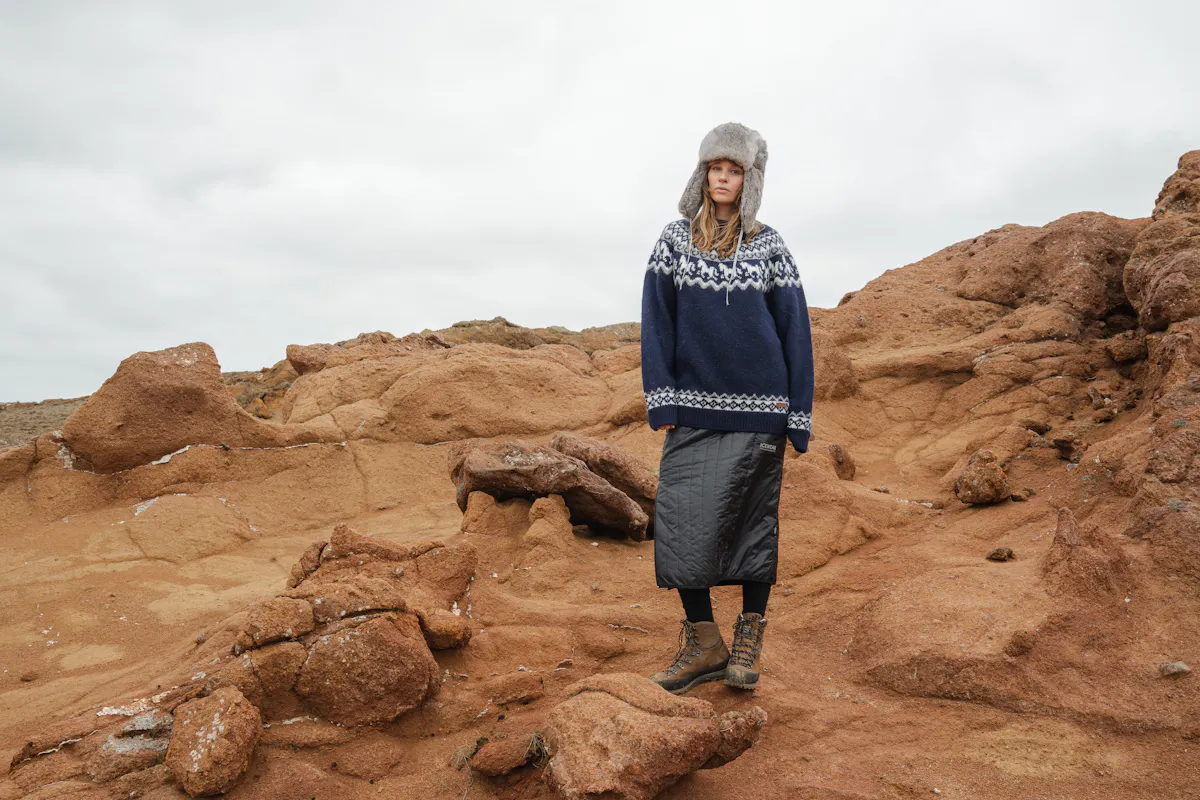 woman wearing Icelandic wool sweater with horse pattern in a rocky nature