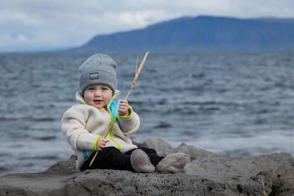 enfant assis au bord de la mer islandaise