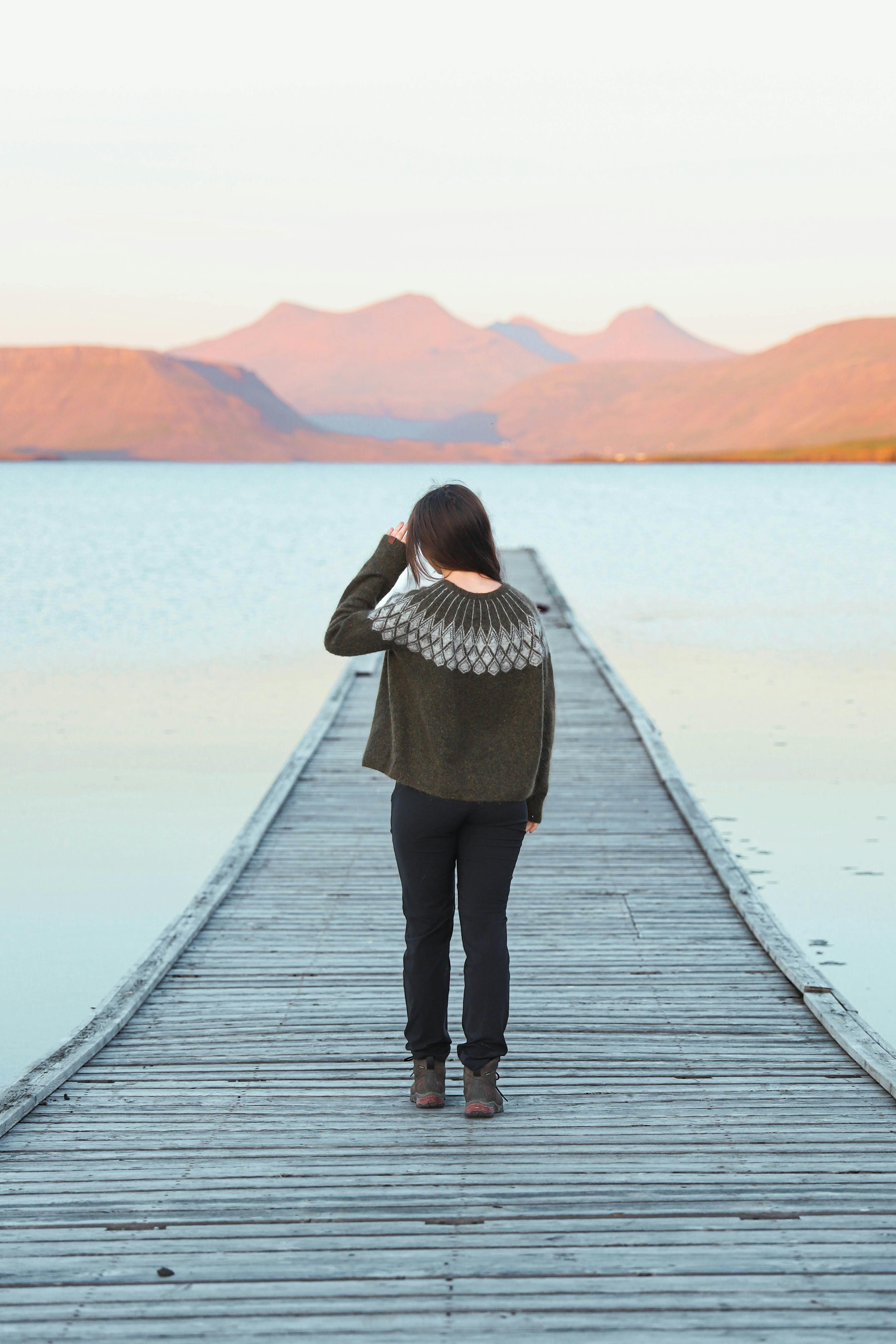 girl on a long pier, looking out to sea