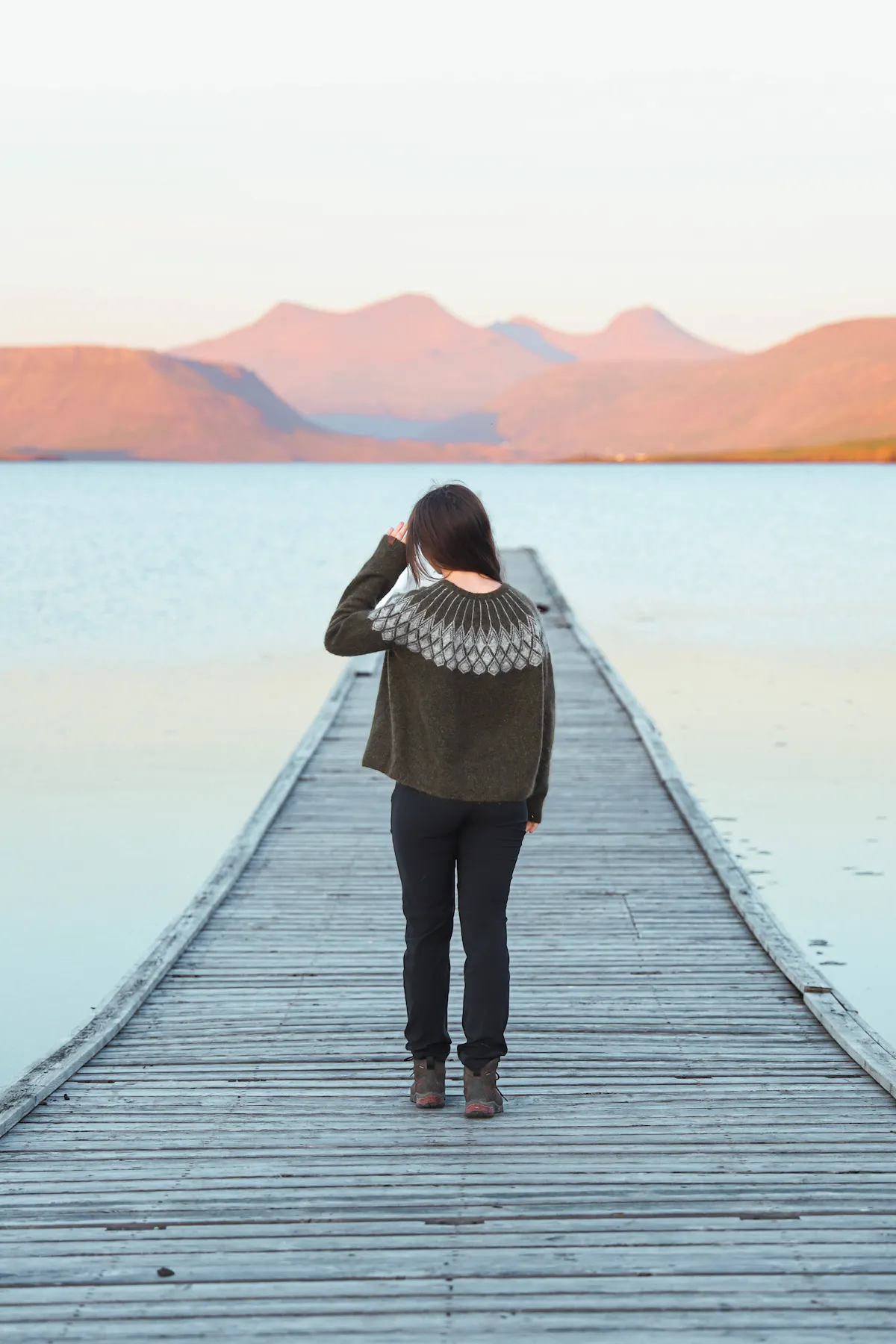 girl on a long pier, looking out to sea