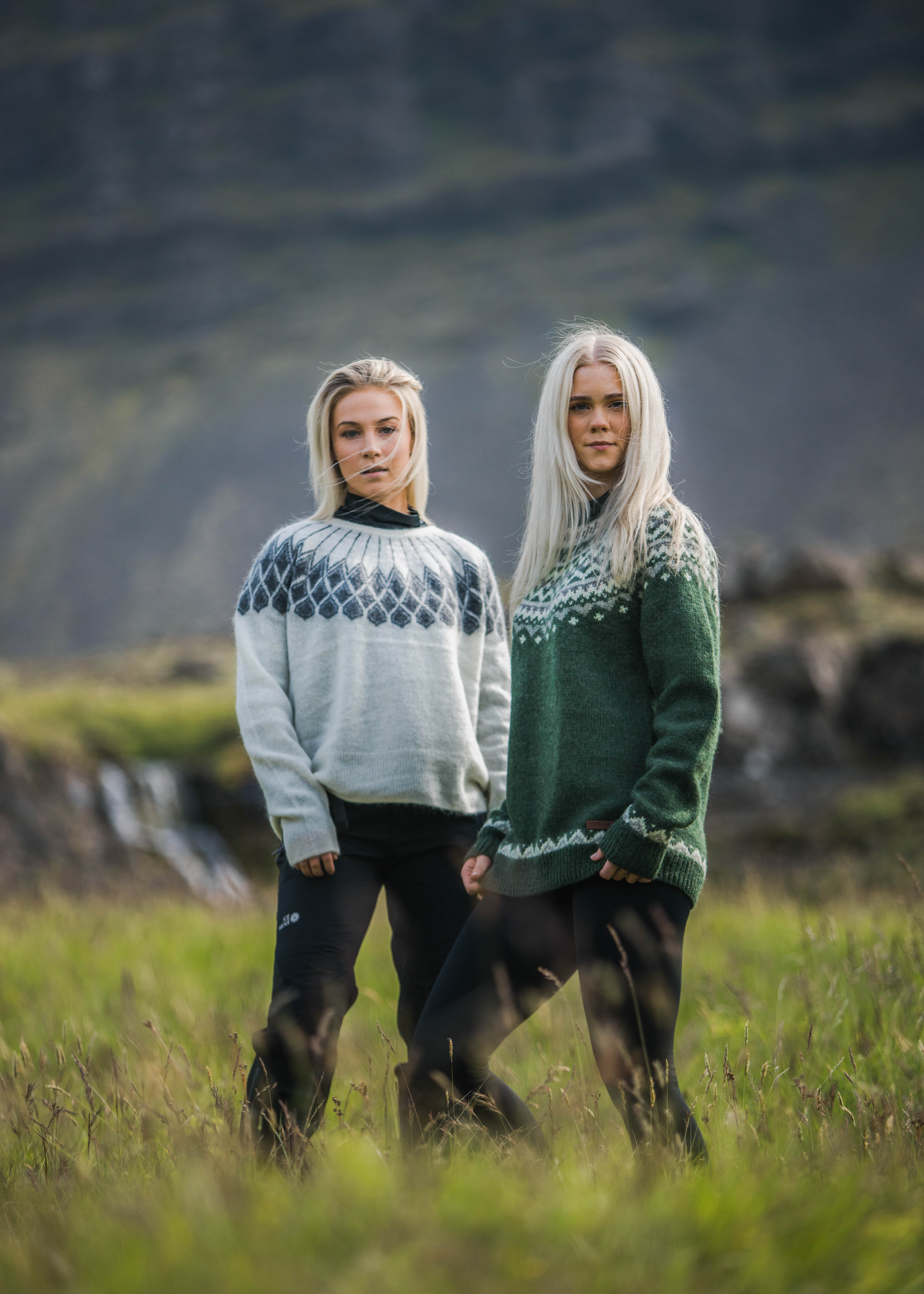 two woman in Icelandic nature, green gras and waterfall behind them