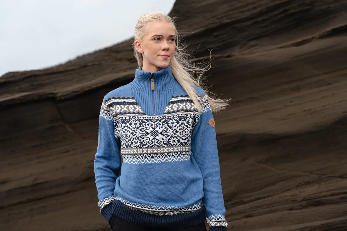 woman standing next to sandy cliff
