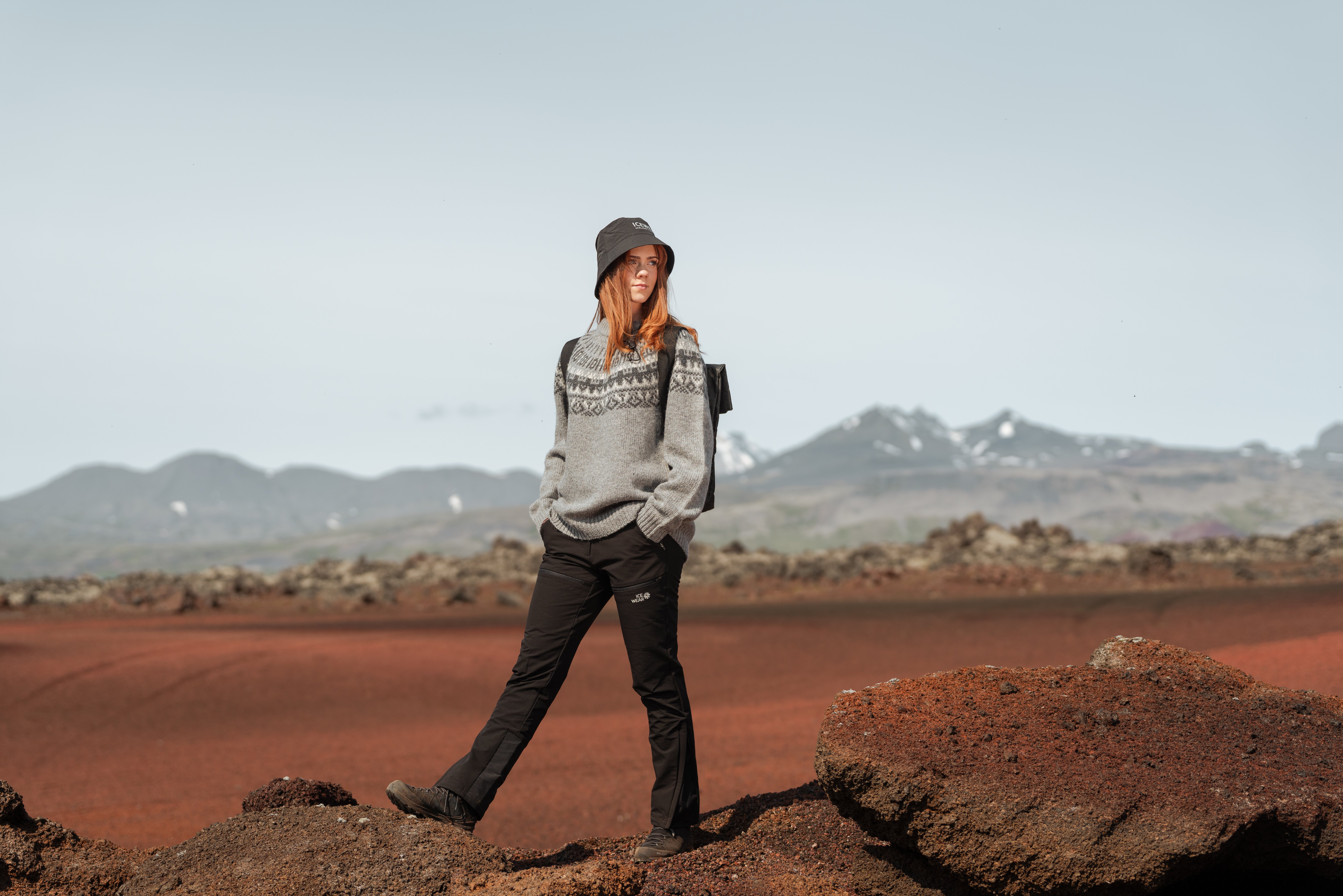 Eine Frau, die in roter Lava im Westen Islands spazieren geht