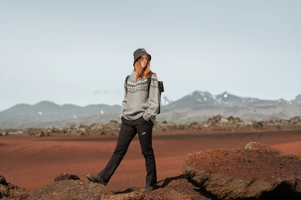Eine Frau, die in roter Lava im Westen Islands spazieren geht