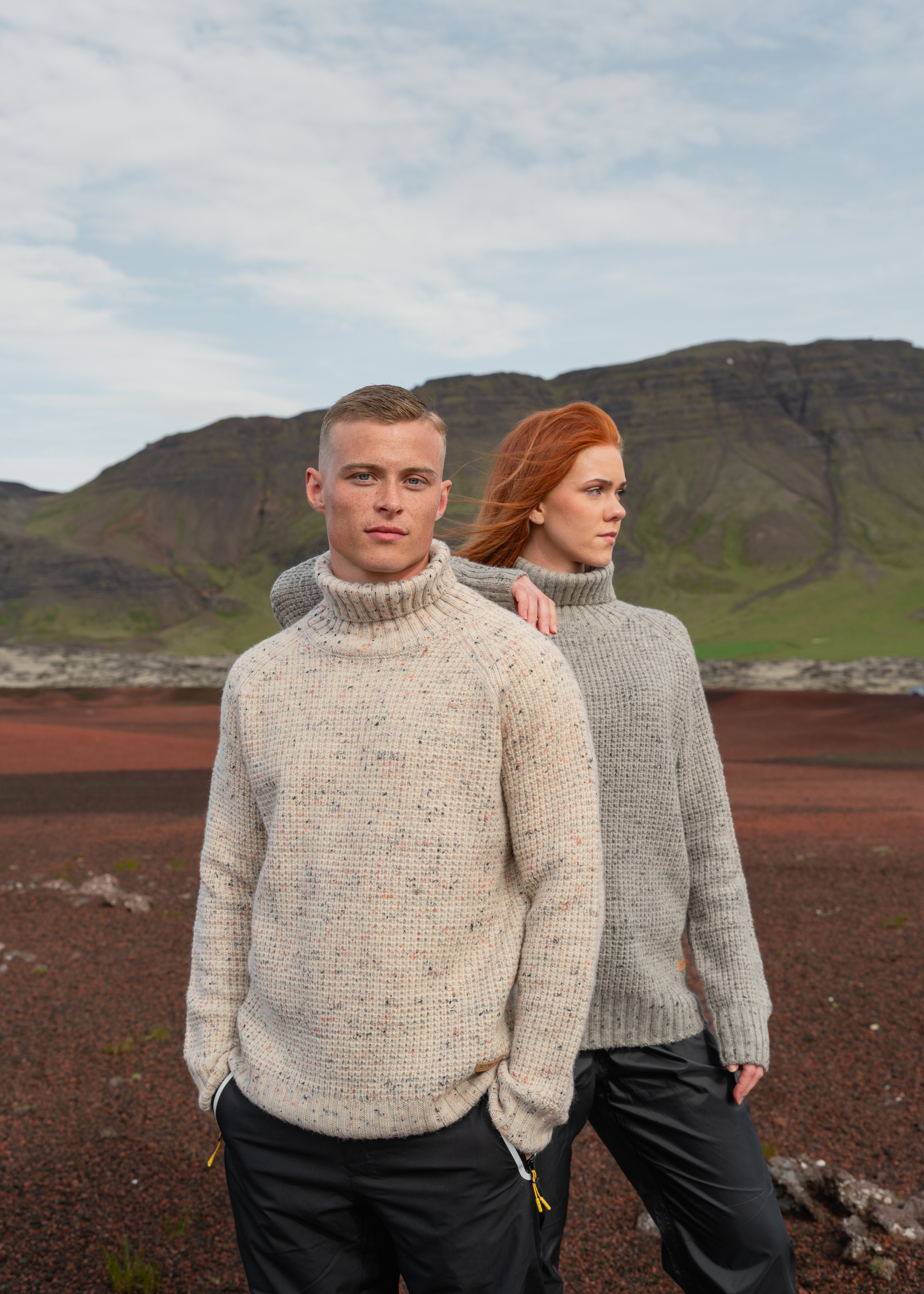 couple standing in red sand in Vest Iceland