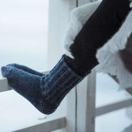 Feet leaning on wooden fence