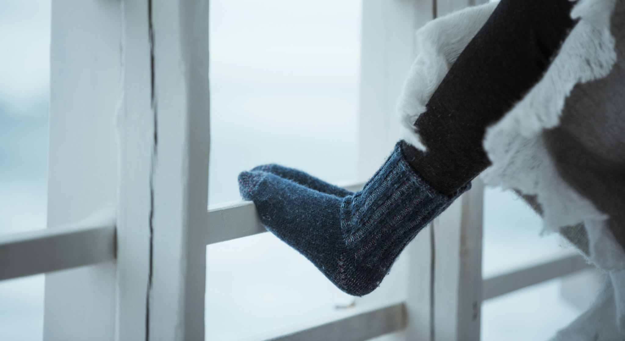 Feet leaning on wooden fence