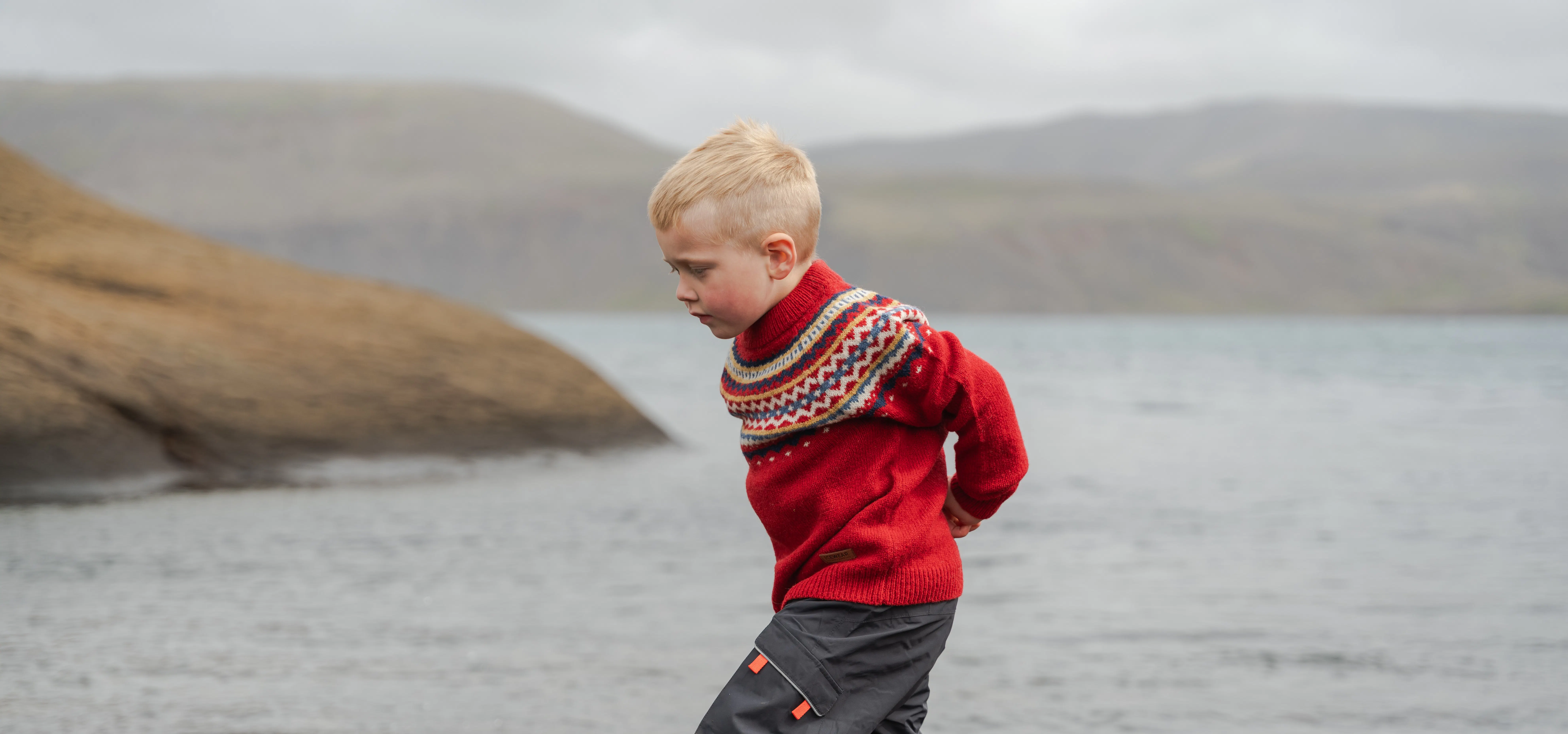 boy running close to the lake