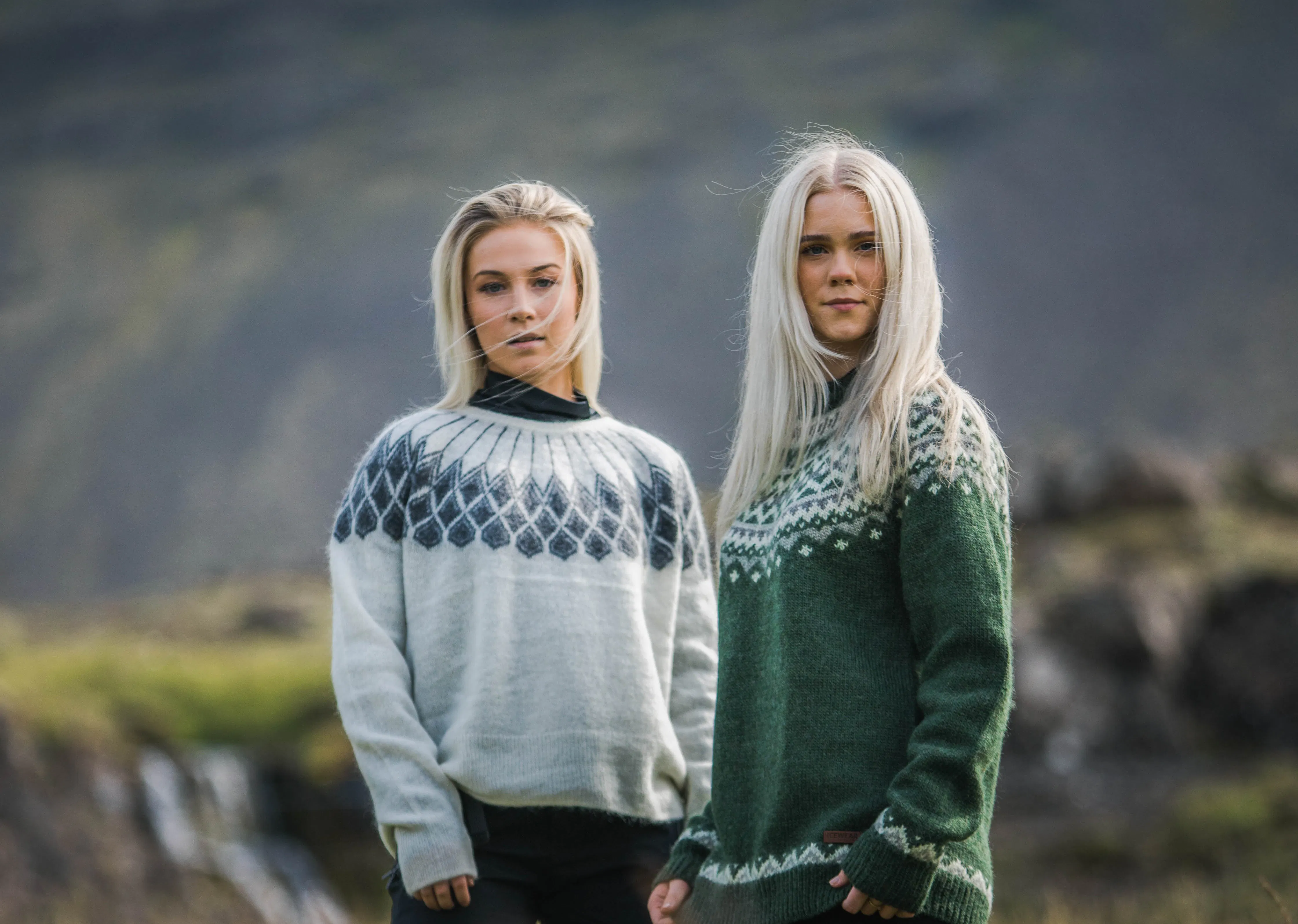 two woman in Icelandic nature, green gras and waterfall behind them